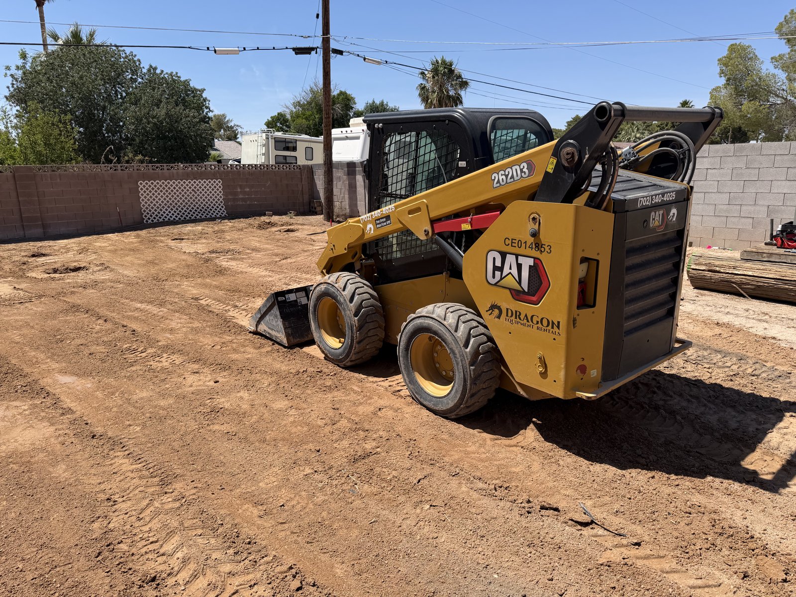 CAT 262D3 Skid Steer with smooth bucket grading dirt on a Las Vegas job site, Dragon Equipment Rentals